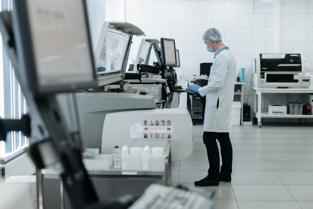 A scientist in a lab coat using advanced laboratory equipment in a clean, modern lab.